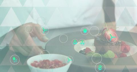 Chef topping chocolate dessert with strawberry and berries on plate with teal tech overlay