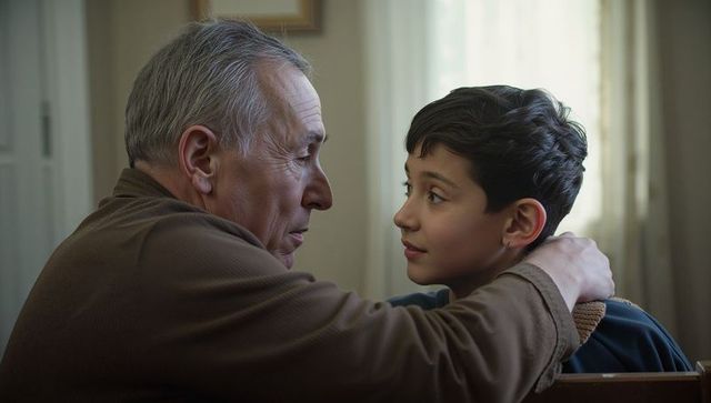 Elderly man embracing young boy during quiet moment of affection in living room
