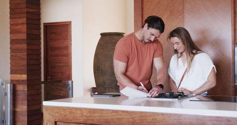 Happy Couple Signing Lease in Modern Kitchen for Their New Apartment