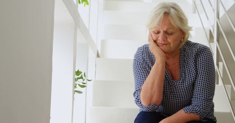 Senior Woman Deep in Thought on Home Staircase - Download Free Stock Images Pikwizard.com