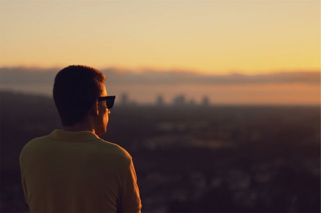 Person Gazing at City Skyline During Sunset - Download Free Stock Photos Pikwizard.com