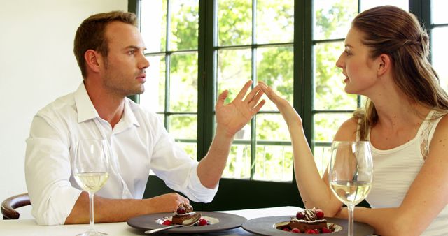  Angry young couple arguing at restaurant