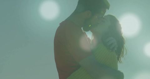 Couple Embracing under Ethereal Sky with Dreamy Light Orbs