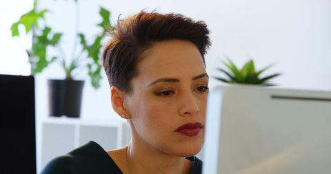 Businesswoman Focused at Computer Desk in Modern Office Setting