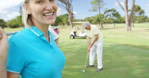 Happy female golfer enjoying game on course