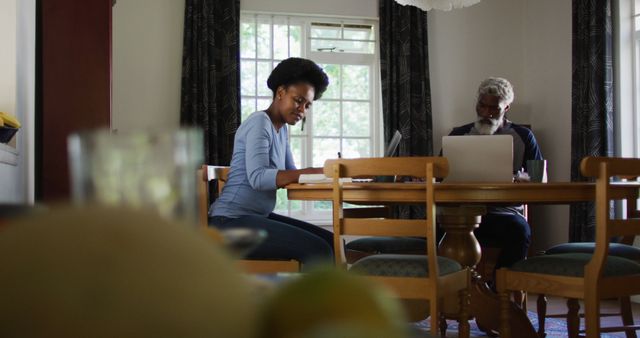 African american couple sitting at dining table using laptops paying bills - Download Free Stock Photos Pikwizard.com