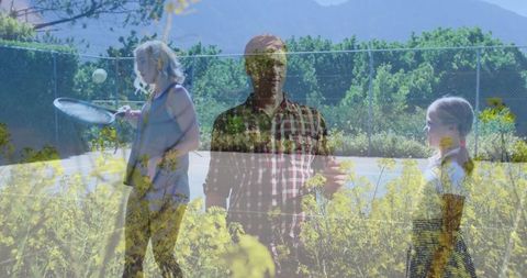 Family Playing Tennis by Bright Yellow Wildflowers Outdoors