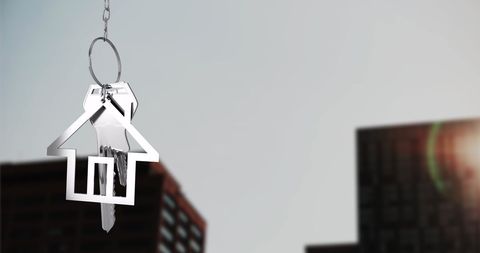 House Keychain Hanging Over Cityscape Background