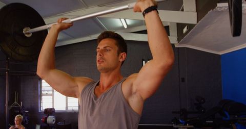 Man lifting barbell in industrial gym for strength training
