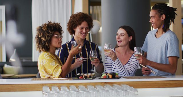 Group of young diverse friends enjoying wine and sushi together in modern, stylish environment. Ideal for advertising social events, food and beverage promotions, lifestyle articles, and communal dining experiences.