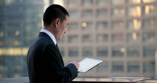 Businessman Using Tablet on Urban Balcony at Sunset - Download Free Stock Images Pikwizard.com