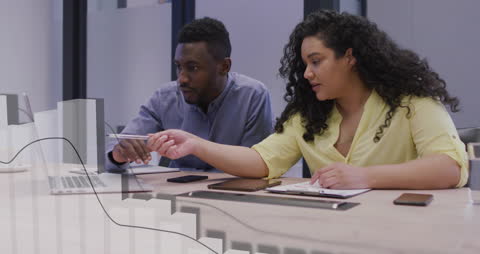 Colleagues Analyzing Financial Data Using Laptop in Office