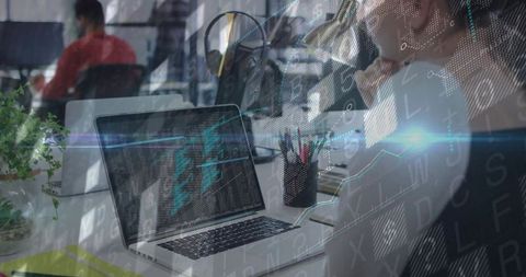 Focused developer coding on laptop in modern open-plan office