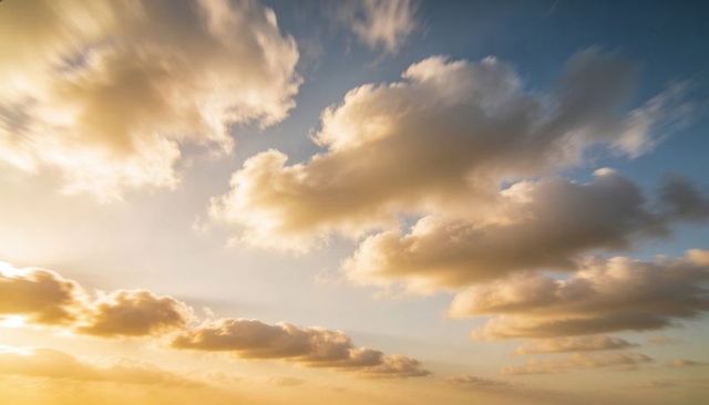Golden sunset clouds drifting across pastel sky with glowing cumulus and serene horizon
