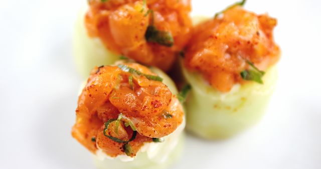 Succulent shrimp seasoned with herbs are presented atop cucumber rounds, offering a refreshing appetizer option, with copy space. Perfect for a sophisticated gathering, these bite-sized delights combine the crispness of cucumber with the savory taste of seafood.