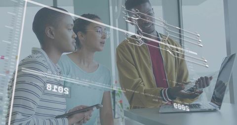 Diverse team collaborating with laptop and tablet, interactive data visualization overlays