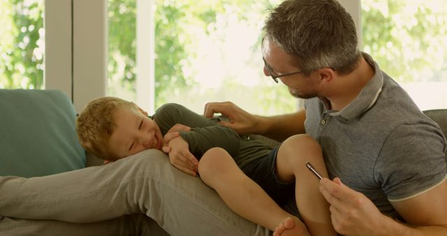 Father and Son Bonding and Laughing Together on Couch - Download Free Stock Images Pikwizard.com