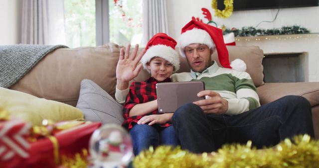 Father and son video calling family during Christmas celebration at home - Download Free Stock Images Pikwizard.com