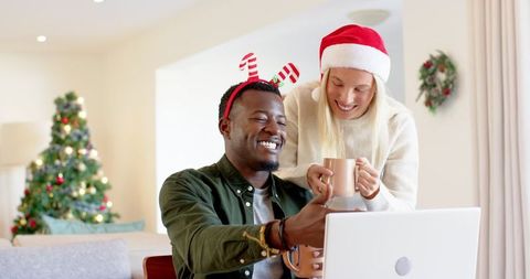 Happy Couple Celebrating Christmas with Laptop and Festive Decorations