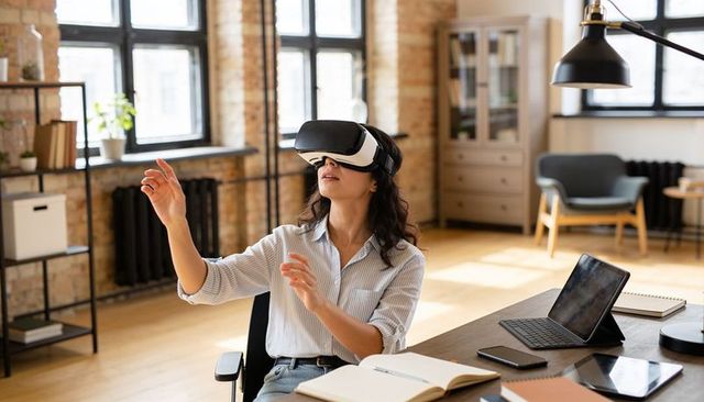 Woman wearing vr headset reaching toward virtual interface in modern loft office workspace