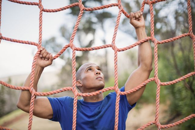 Fit man climbing a net during obstacle course - Download Free Stock Photos Pikwizard.com