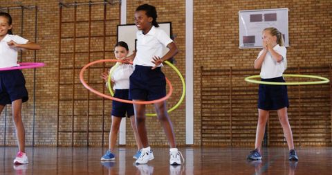 Children Playing with Hula Hoops in School Gym