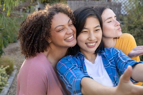 Diverse friends taking selfie in backyard garden celebration