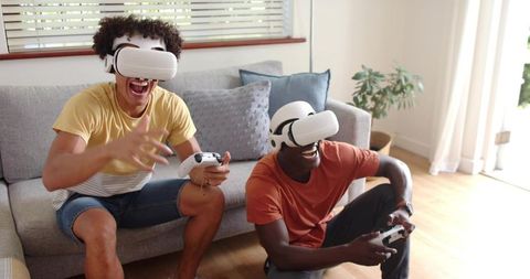 Friends Playing Virtual Reality Multiplayer Game at Home Wearing White VR Headsets