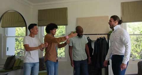Groom Supported by Groomsmen During Wedding Day Preparation