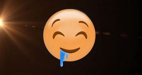 Whimsical drooling emoji on black background with lens flare