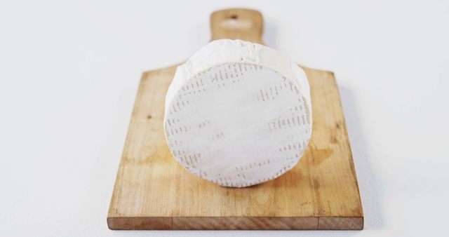 Cheese on wooden board against white background