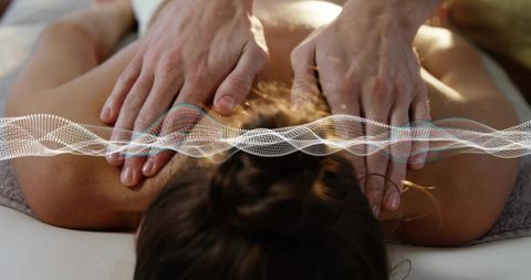 Closeup therapist hands massaging upper back with waveform visual for spa wellness therapy