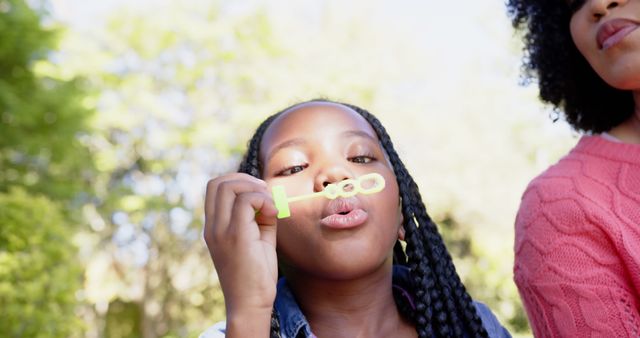 Happy african american mother with daughter blowing bubbles in garden at home - Download Free Stock Photos Pikwizard.com