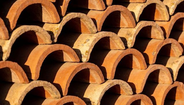 Sunlit Terracotta Roof Tiles Forming Rhythmic Semi-Cylindrical Arch Pattern