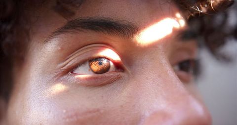 Macro close-up of eye with sunlight reflection on iris