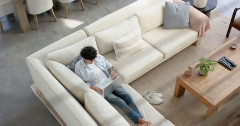 Young Man Relaxing with Laptop in Modern Minimalist Living Room
