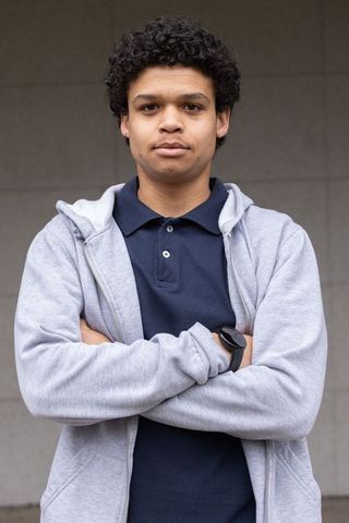 Confident african american man standing with arms crossed wearing hoodie and smartwatch