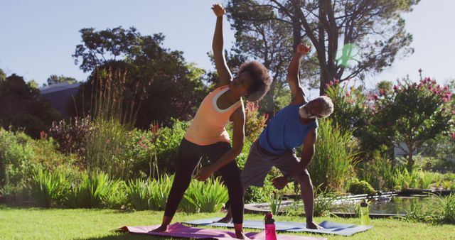 African american senior couple exercising outdoors stretching in sunny garden. staying at home in isolation during quarantine lockdown.
