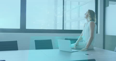 Businesswoman Contemplating in Modern Day Office with Data Projections