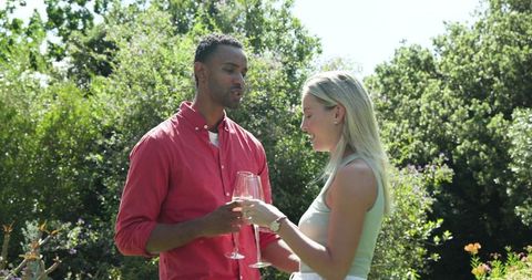 Happy Couple Embracing with Champagne in Sunny Garden
