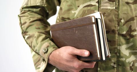 Military personnel holding notebook, planning and documentation concept
