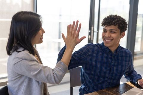 Diverse Coworkers Giving High Five in Modern Office Environment