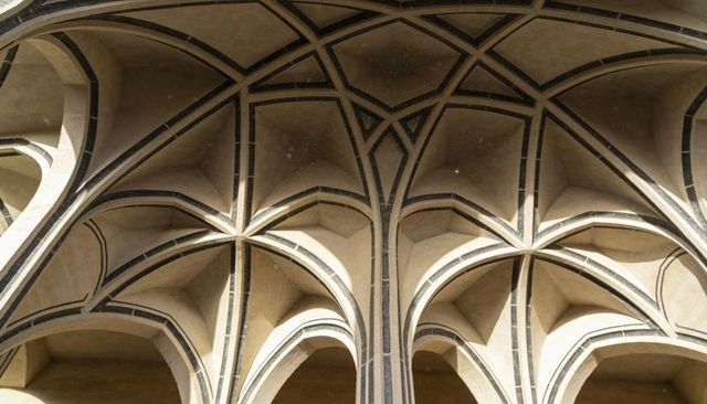 Ribbed gothic vault featuring pointed arches and dark inlay bands