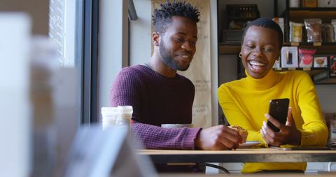Smiling Friends Enjoying Technology and Coffee in Cafe