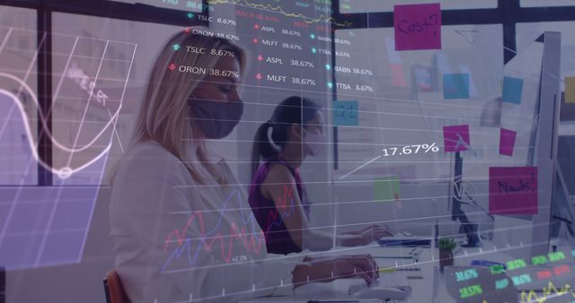 This stock photo is ideal for illustrating concepts of modern business analysis and teamwork in a professional environment. The image showcases women working in an office setting, with digital data projections overlaying the scene. Useful for websites, articles, and presentations related to finance, technology, data analytics, business strategies, and corporate environments.