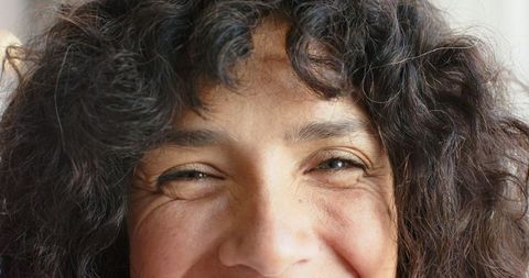 Close-Up Portrait of a Confident Smiling Woman with Curly Hair
