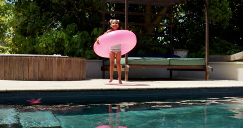 Young Girl Enjoying Summer by Swimming Pool with Inflatable Ring