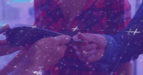 Swapping smartphone and card at retail counter with denim jacket and purple tech overlay
