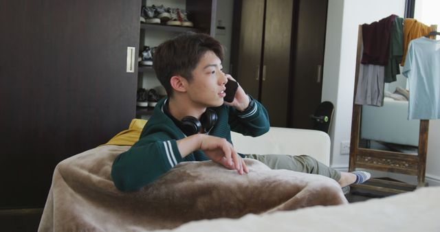 Young man talking on phone in modern bedroom - Download Free Stock Images Pikwizard.com