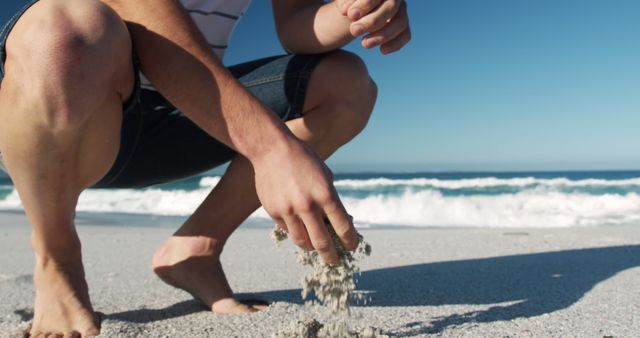 Person Kneeling on Beach Sifting Sand on Sunny Day - Download Free Stock Images Pikwizard.com